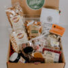 Gift box with locally made products including: coffee, peppermint bark, beef sticks, snickerdoodle popcorn, peppermint stroopie, jam, caramels, soup, seasoned pretzels, cinnamon bun popcorn, and non pareils.