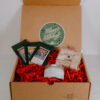 Gift box with locally made marshmallows, hot chocolate packets, and a hot chocolate flavored candle.
