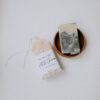 bar soap in wooden bowl with packaged soap laying next to it