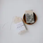 bar soap in wooden bowl with packaged soap laying next to it