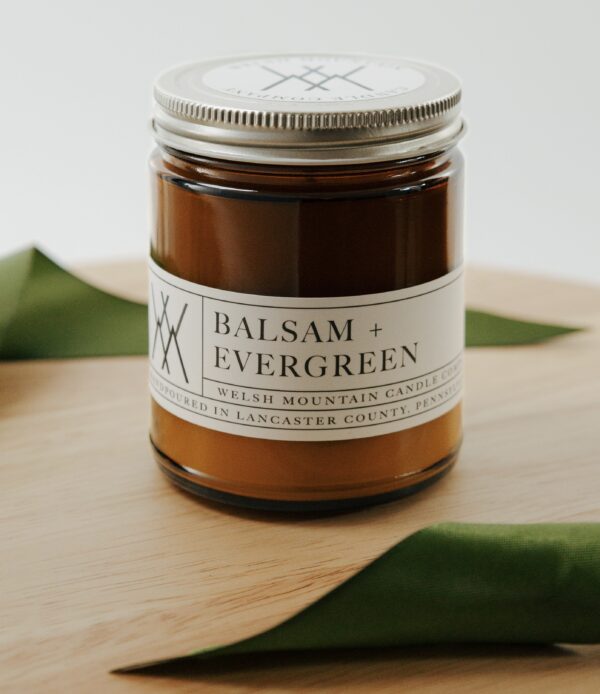 Balsam + Evergreen scented candle. Made locally by Welsh Mountain Candle Company in Lancaster County, PA. In an amber glass jar.